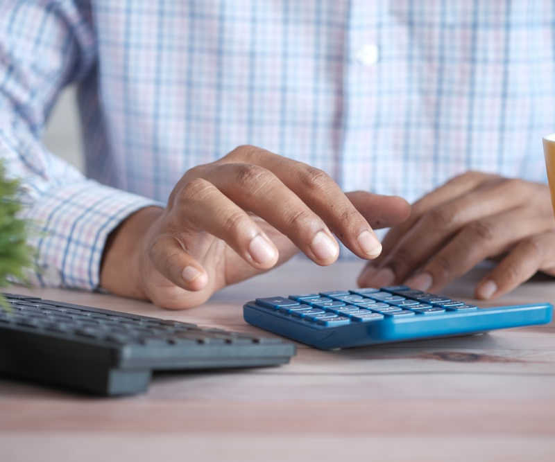 A man in a formal shirt using a calculator